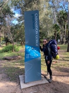 A photo of Hannah in front of a sign on her Carnarvon Gorge Great Walk.