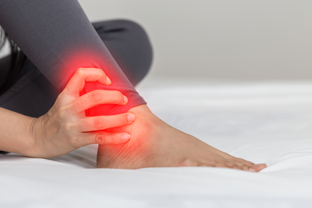 A picture of a foot with a person holding on to the ankle which is inflamed.