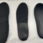 The underside of three pairs of orthotics