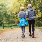 An older man an woman walking through the country getting exercise and looking after aging feet