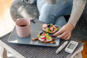 Young diabetic woman having breakfast at home demonstrating diabetes and your feet
